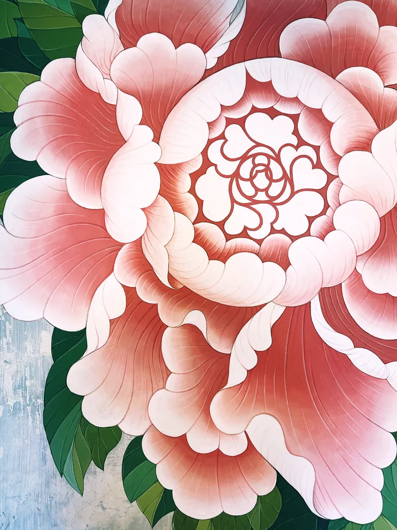โบตั๋น mural เต็มดอกที่ Luda วาดบนผนังปูนเก่าบ้านอาจ้อ — กลีบชมพูทุกกลีบเป็นรูปหัวใจ ใจกลางคือลายโลโก้