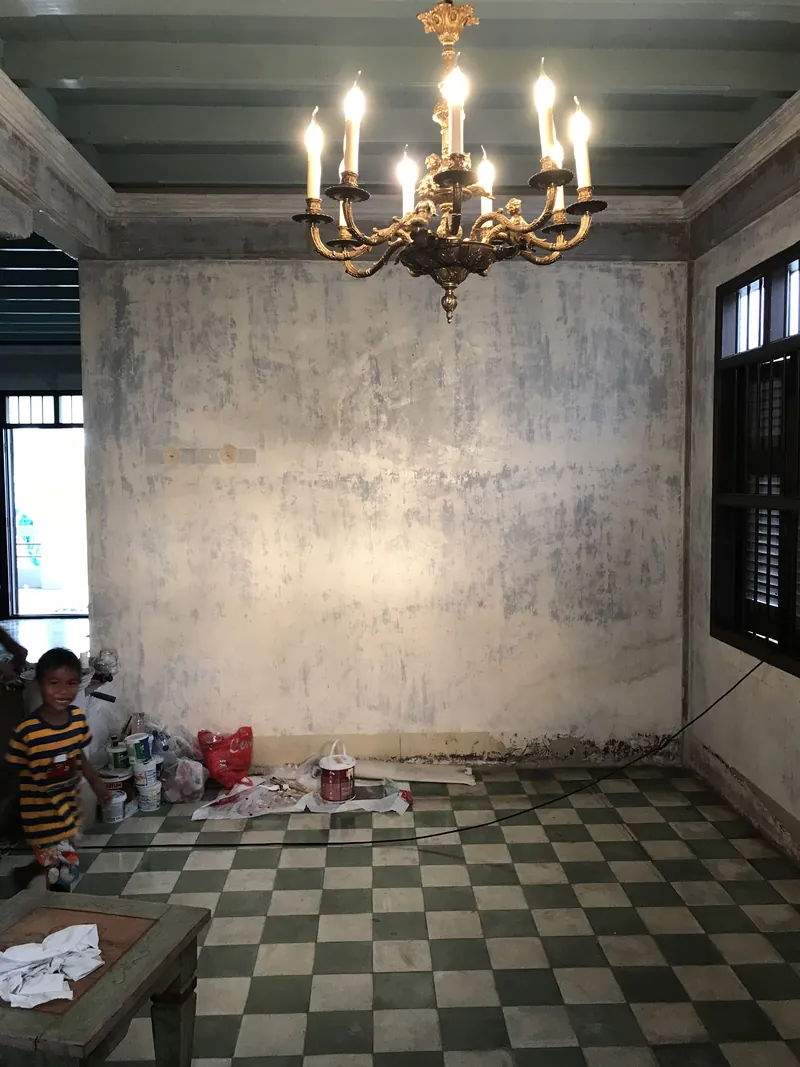 โถงในบ้านอาจ้อหลังเคลียร์สีหลุดร่อนเสร็จ ผนังยังว่าง โคมระย้าติดแล้ว รอรูปครอบครัวกลับขึ้นผนัง ธันวาคม 2018